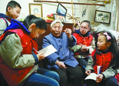 昨天，全媒体记者和赤壁路小学的四名南京日报小记者一起来到南京大屠杀幸存者杨翠英家中采访。南京报业传媒集团全媒体记者 崔晓摄