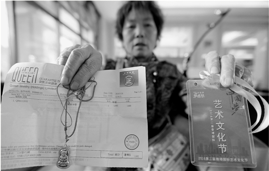 吴宝园向记者展示在澳门所购的“金镶玉”挂件及相关票据。