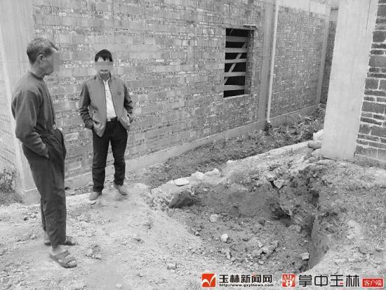 村民苏某兴（左）说，木材就是在这泥坑挖到的。