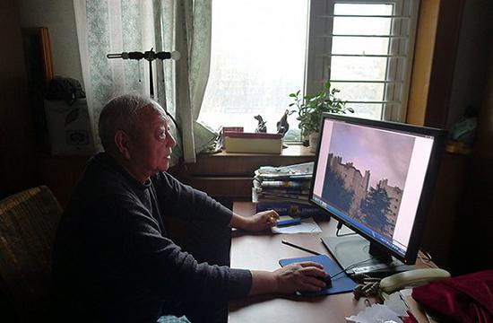 王汝春在电脑上整理着他拍摄的雾霾照片。摄影：孙俊彬。