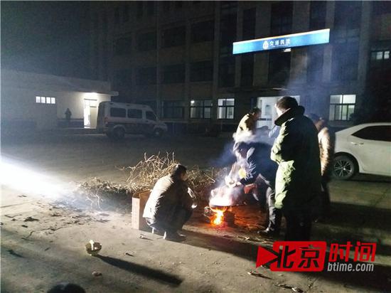 货车司机在交通执法局院内生火做饭 图/北京时间