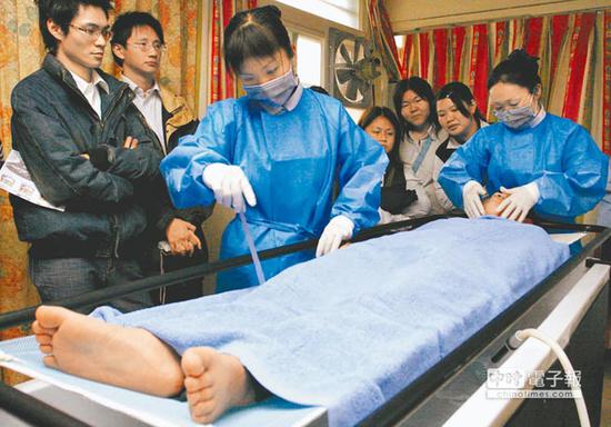 图为殡葬业者教导实习礼仪师为“大体”洗身。（图片来源：台湾《中国时报》）
