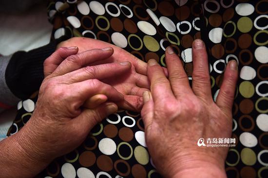 尹爱莲的左手已经可以活动，但右手还是处于蜷缩状态，婆婆每天都要给她按压。