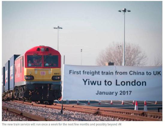 ▲火车进站的终点线上，一个横幅写着“历史首列从中国到英国的列车”。