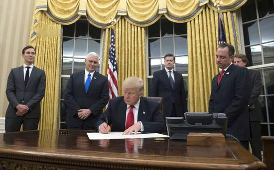 20日，特朗普在换上金黄色窗帘的总统办公室里签署了第一份总统令。