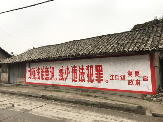 江口镇一处民房粉刷着一行标语，“增强法治意识，减少违法犯罪。”新京报记者韩雪枫摄