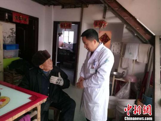 万少华探望烂脚老人。 王颖珺 摄