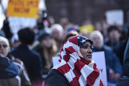 29日，一名围着美国国旗头巾的妇女在纽约听演讲者抗议特朗普的“限制入境令”