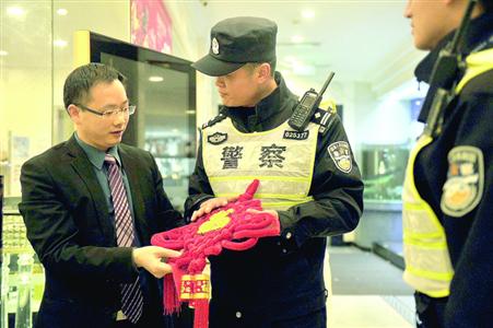 值勤民警向商户赠送中国结/警方供图