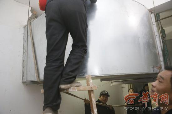 小区物业工作人员用绳子将侯先生拉上来 华商报记者 张杰 摄