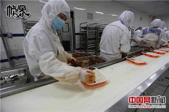 工人在流水线上将处理好的菜肴装入饭盒。中国网记者 吴闻达 摄
