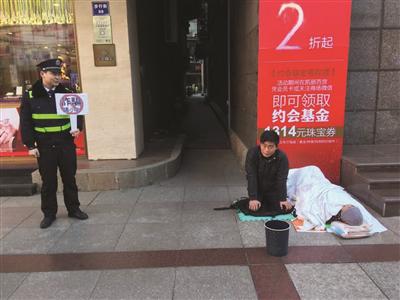 协管员举牌，男子硬着头皮继续跪着乞讨