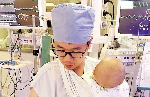 男护士身“挂”小患儿工作照走红 被称“奶爸”