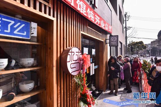 图：2月19日早上8点，在上海中华路的梦花街馄饨店门口早已门庭若市。（新华网严晓瑜 摄）