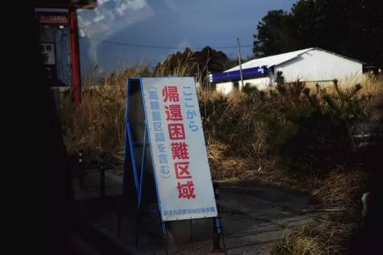 记者在福岛核事故核心区域拍摄，标语为“有高辐射地区，不建议迁回”