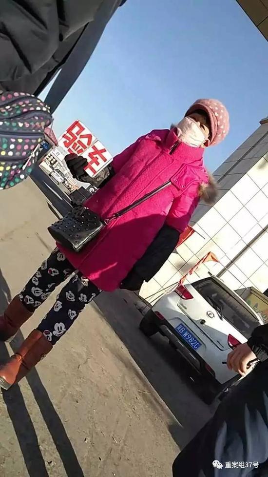 ▲河北唐山吉祥二手车市场门口,一名贩子手持验车牌子招揽顾客