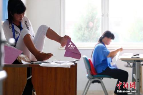 资料图:图为正在参加残疾人职业技能竞赛的选手。中新社发 富田 摄