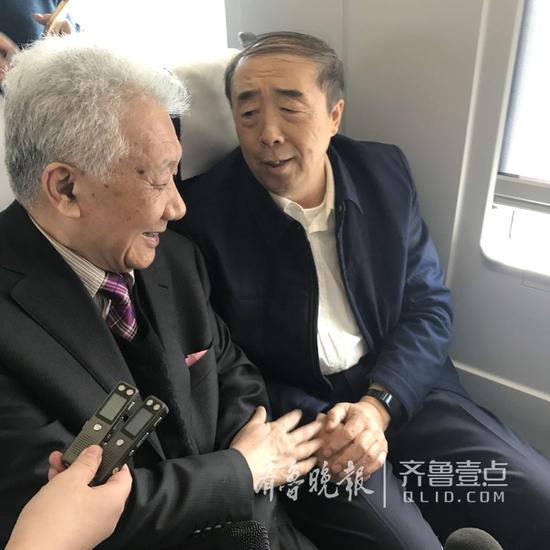 全国政协委员栗甲（右）和刘大钧在火车上正在进行交流。