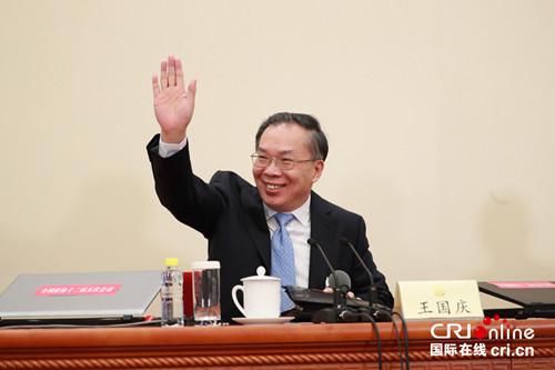 发言人王国庆向现场记者招手。摄影：沈湜
