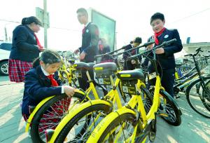 日前，地坛小学的“小雷锋”们来到安定门地铁公交枢纽，将地铁口无序停放的共享单车整齐地摆好，方便行人取车。北京晨报记者 李木易/摄