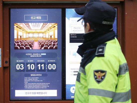 △首尔钟路区宪法法院公告栏上显示朴槿惠弹劾案宣判日期，韩国3月10日上午11点（北京时间10点）。图自视觉中国