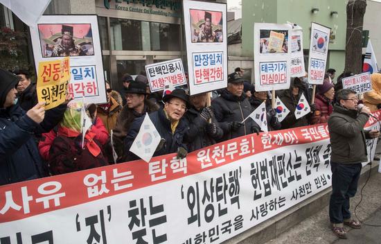 △2月8日，韩国被停职总统朴槿惠支持者在宪法裁判所前集会示威，手举“包青天”头像抗议总统弹劾案。图自视觉中国
