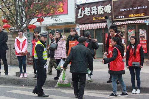 交巡警和志愿者对横穿马路的老人进行劝导。