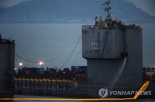 当地时间3月22日晚，韩国海洋水产部正进行世越号船体试捞作业。（图片来源：韩联社）