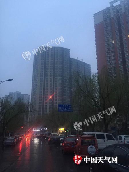 今晨，北京雨雾濛濛，路面湿滑。