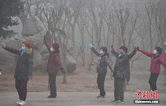 图：2017年1月2日，在河北石家庄一公园，一群大妈正戴着口罩运动健身。中新社记者 翟羽佳 摄