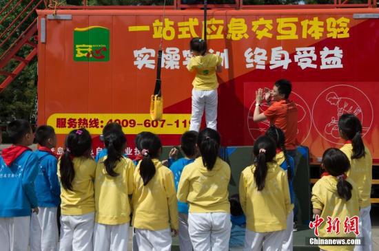 资料图 防灾减灾日北京小学生进行应急体验互动 中新社记者 崔楠 摄