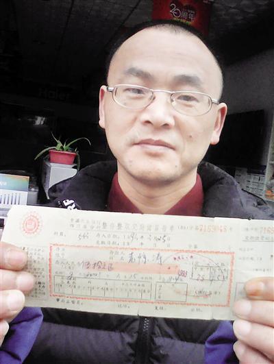 昨日,袁津涛向记者展示24年前的存款单据。 本报记者 胡杰摄