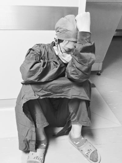 29日下午，两台手术间隙，医生江喜娇累得坐在地上睡着了    医生方建国提供