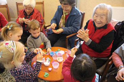 ▲“一老一小”活动现场，孩子们向老人展示自己的手工作品，老人们表示赞许（2月28日摄）。