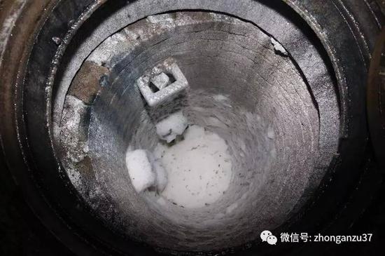 2015年4月9日夜，后厂村路和西二旗桥交口，掀开“洒水车”排放垃圾渗沥液的井盖，井里白色泡沫散发着恶臭味。  新京报记者尹亚飞 摄