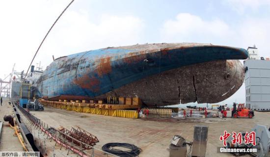 据韩媒报道，当地时间9日17时35分，韩国 “世越”号沉船成功上岸，运送过程历时约8个半小时。图为当地时间4月1日，在韩国木浦港，被打捞出水的“世越”号沉船等待被移送上岸。