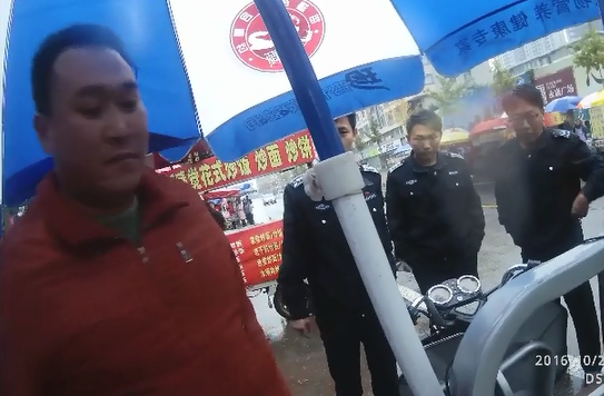 城管扣车导致双方发生争执,随后张军虎拔刀刺向城管。视频截图