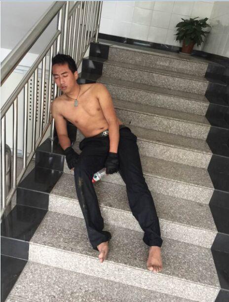 救人之后,巡警周维鹏累倒在楼梯上。