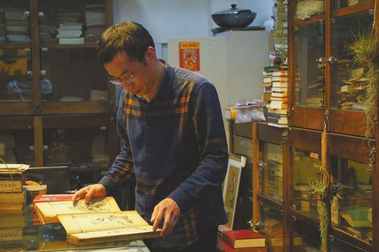 郭云龙在翻看收藏的古籍。