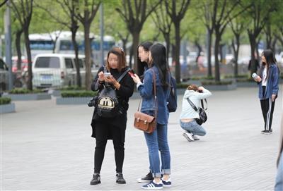 　　4月19日，北京三里屯，女摄影师(左边黑色上衣)拍完照，向被拍女子要联系方式，之后会有多个电话打来，让被拍者应聘兼职模特，掏钱再拍宣传照以及上杂志。　新京报记者 王飞 摄