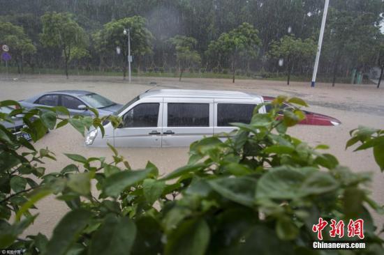 2017年5月7日中午,广州番禺区里仁洞跨线桥下道路因暴雨积水水位迅速上升,有十多部小汽车来不及通过被困水中,整条道路交通一度中断。图片来源:视觉中国