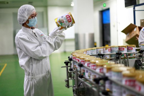 伊利质检员仔细检查产品外包装。