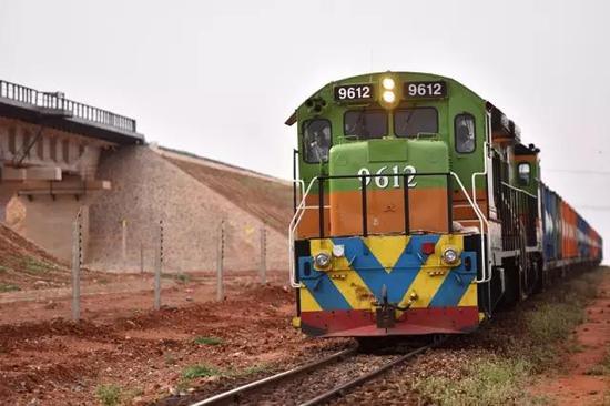 在肯尼亚沃伊附近，一列货车行驶在蒙内铁路旁的老式米轨铁路上。 新华社记者孙瑞博摄