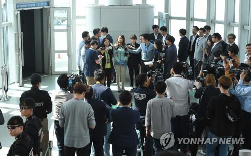 5月31日下午，韩国仁川机场，崔顺实的女儿郑某戴着手铐答记者问。图片来源：韩联社
