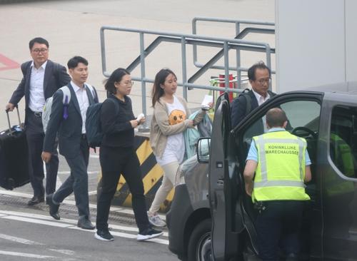 5月30日，在荷兰阿姆斯特丹机场跑道，韩国检方人员护送郑某上车。（图片来源：韩联社）