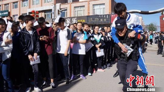 图为内蒙古民警背着受伤考生将他送进考场。　赵晓华　摄
