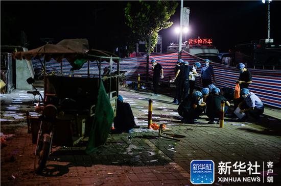 6月16日凌晨，法医等工作人员在江苏丰县创新幼儿园门前做清理、鉴定工作。新华社记者李响摄