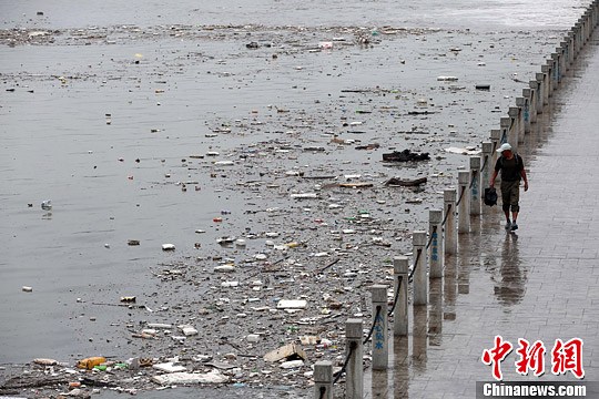 资料图:山西太原遭遇暴雨袭击,雨水将大量垃圾冲入汾河公园河道内,致使河面漂浮大面积垃圾,造成河水污染。中新社发 武俊杰 摄