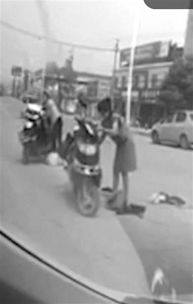 两位女士扶起电瓶车后小车司机驶离