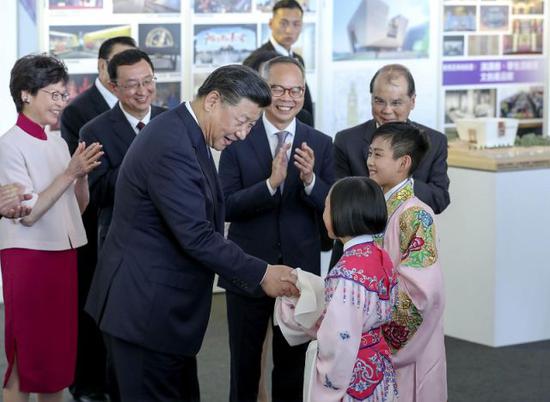 ↑6月29日下午，国家主席习近平在香港西九文化区出席《兴建香港故宫文化博物馆合作协议》签署仪式。这是习近平同现场演唱粤剧选段的两名儿童亲切交谈。新华社记者 丁林 摄